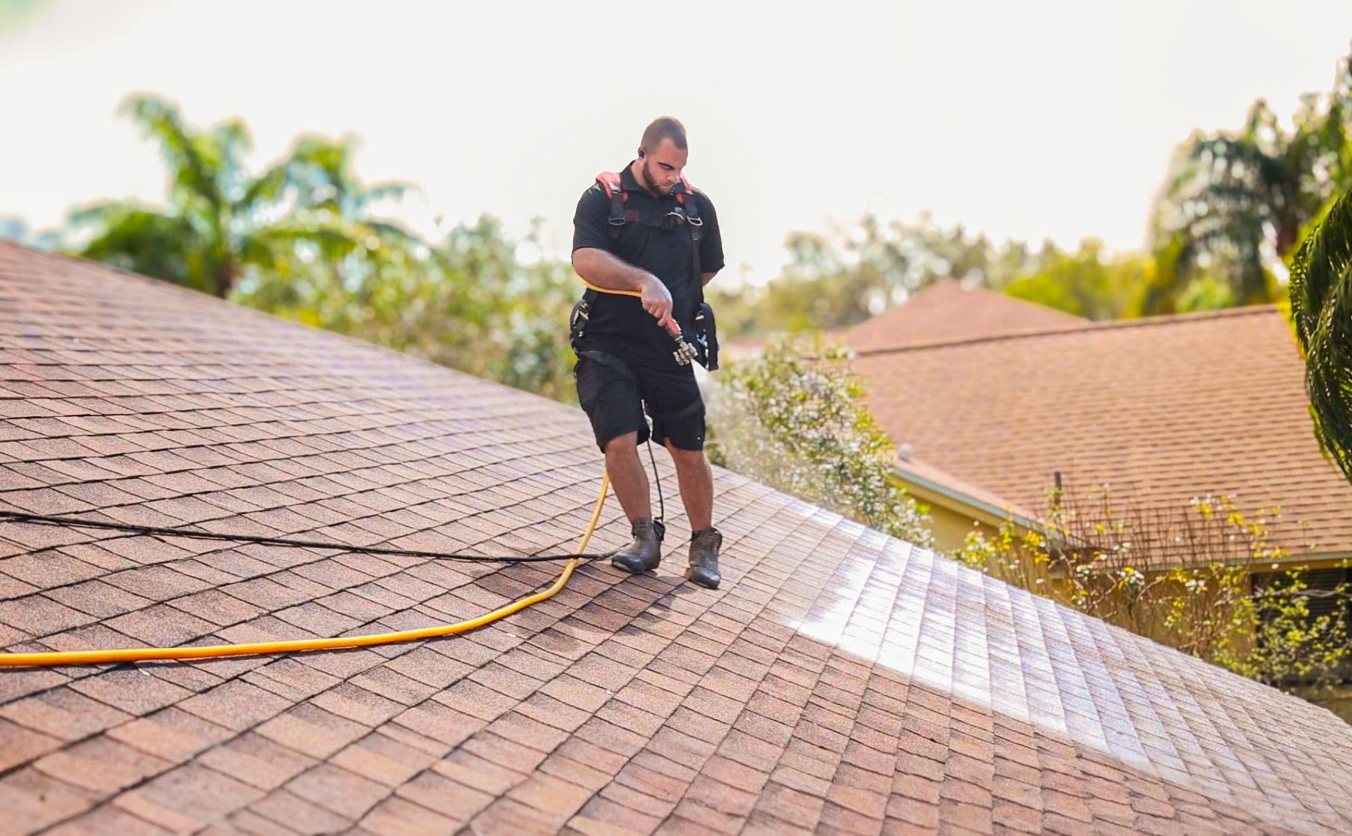 Shingle Hero technician applying roof rejuvenation